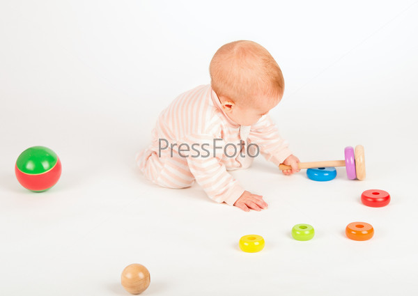 Happy baby playing with a toy pyramid on white background, stock photo