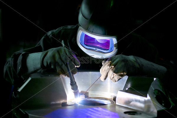 Welder, working on the center ring of a large metal part