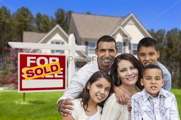 Happy Hispanic Family in Front of Their New House and Sold Home For Sale Real Estate Sign, stock photo