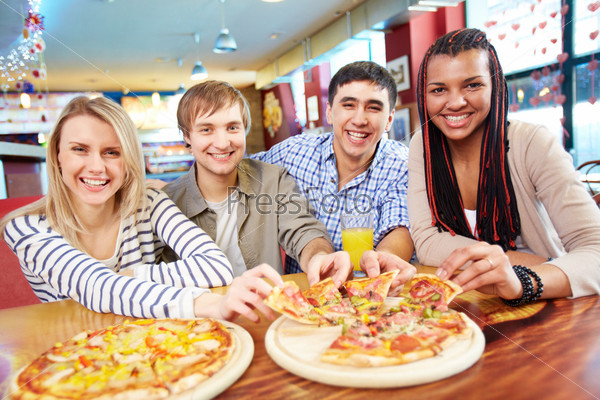 Image of happy teenage friends eating pizza in cafe