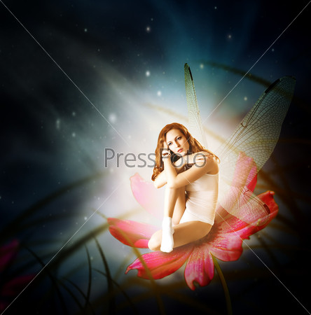 Fantasy. Magical young glowing woman as fairy firefly with wings sitting on flower in moon light