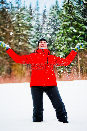 Female throwing a pile of snow up into the air. Female is in focus.