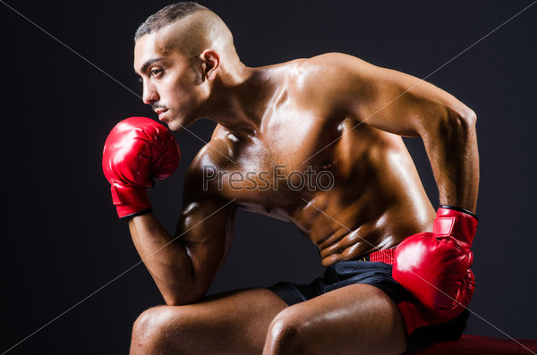 Boxer with red gloves in dark room, stock photo