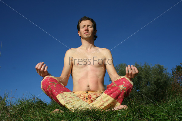 man meditating in park