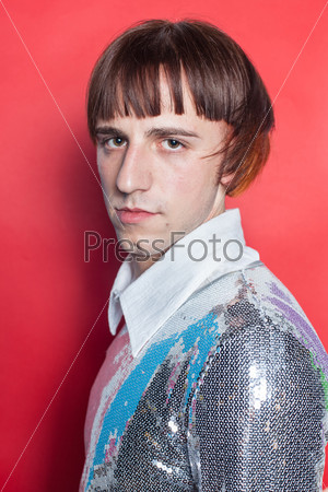 Young man on red background dressed in sequin metallic disc shirt