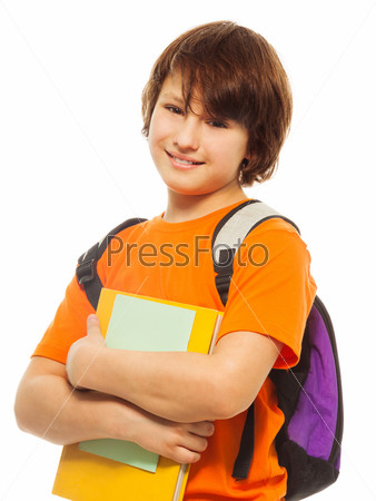 Waist up portrait of happy and smiling teenage boy holding pile of books and wearing backpack on white