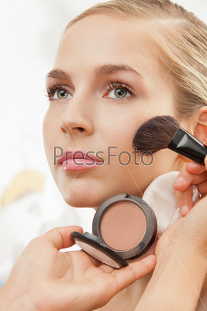 Makeup artist apply blush on cheeks