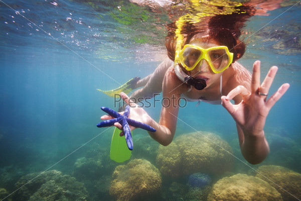 Girl in scuba mask holding starfish