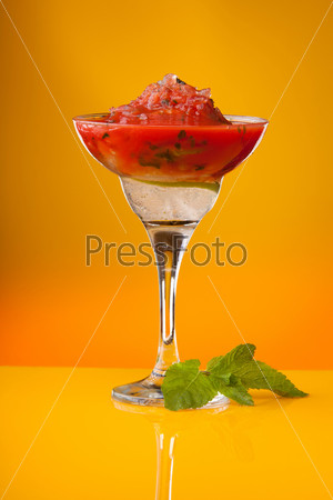 Glass of watermelon gin cocktail on yellow background