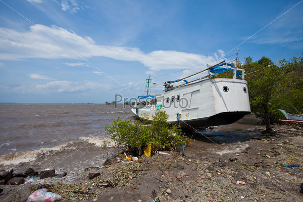 BALI - JANUARY 26. Boat washed up on shore of storm on January 26, 2012 in Bali, Indonesia. Material damage and six people lost their lives in windy storms.