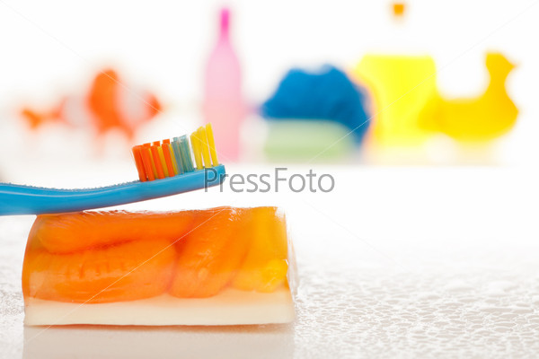 Brush your teeth every day - kids tooth brush with toys and bath accessories on background