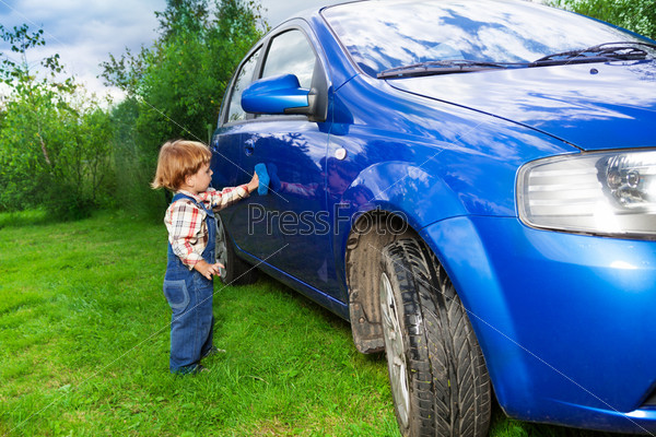 Очаровательный ребенок помогает мыть автомобиль