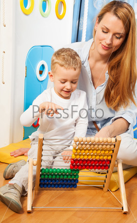 Mother and her little son learning math with abacus