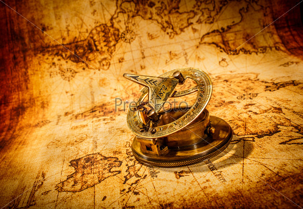 Старинный компас лежит на карте древнего мира