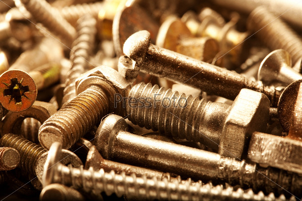 Warm color metal screws close up lay in storage