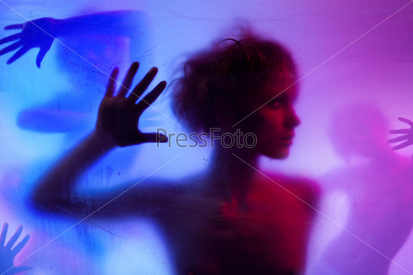 Silhouette  of young woman listening standing behind curtain