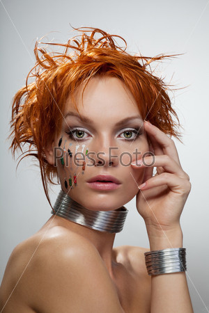 Studio fashion portrait of young futuristic woman with chips\
on her face and grey background