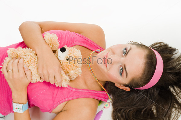 Woman with toy lay on the floor in vivid bright clothes with\
long hair