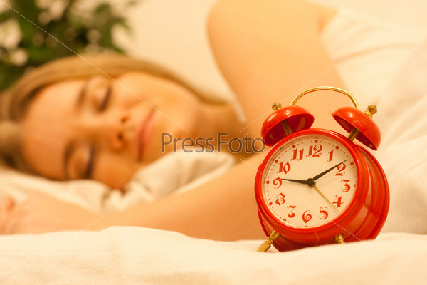 Red alarm and woman sleep on background, stock photo
