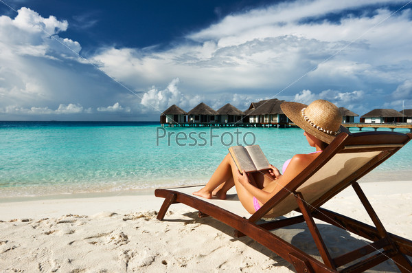 Женщина читает на пляже