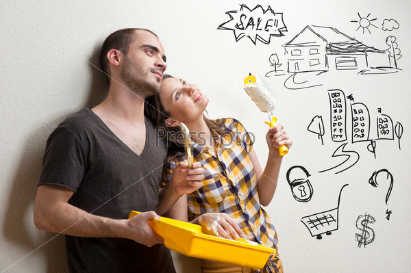 Closeup portrait of adult couple sitting on floor at their apartment and planning renovation of their new apartment while resting during housework