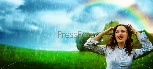 Young woman under storm rain. She is happy and wet