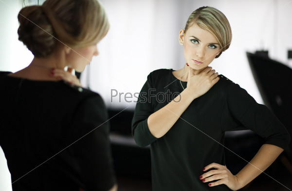 young woman looks in a mirror