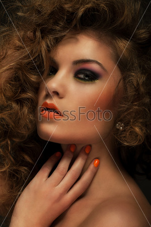 Beautiful caucasian woman with curls and evening makeup