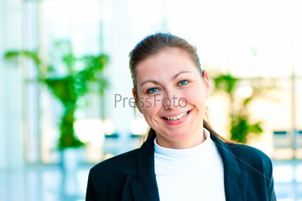 Портрет улыбающейся бизнес-леди на фоне офиса