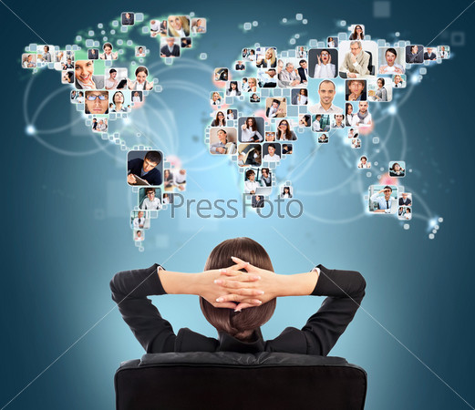 Portrait of young woman communicating with her friends across the world. Sitting against world map with photo of people. International communications concept