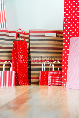 Assorted shopping and gift red paper bags - shopping and holiday concept with copyspace