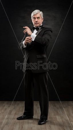 Full length portrait of handsome mature business leader over black background