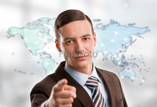 Portrait of young man standing in front of big world map and looking at camera. Server locations and actual online connections are displayed on virtual map. Hosting provider concept.