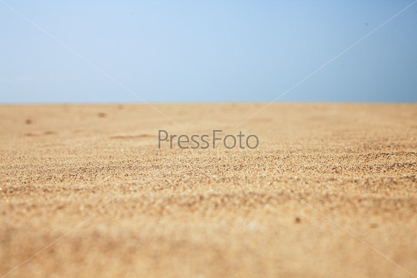 Dry beach sand and clear blue sky close-up