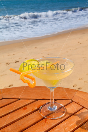 daiquiri cocktail with ice on the table against the background of sea and sky