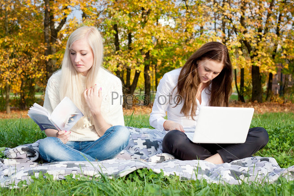 Girls study in autumn park