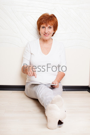 Mid woman with tablet computer. Mature female with digital tablet at home
