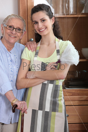Молодая женщина в фартуке с пожилой женщиной