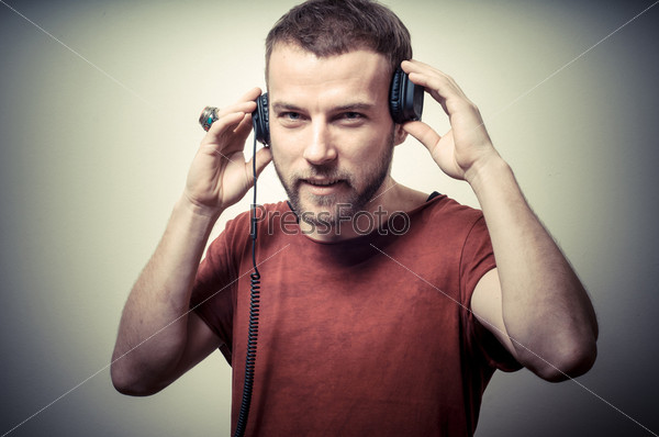 vintage portrait of fashion guy with headphones on gray background
