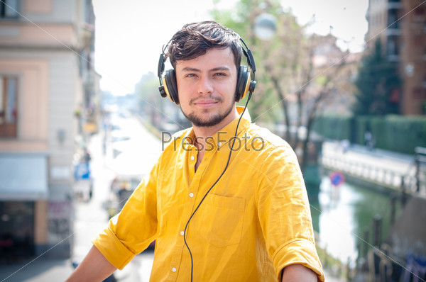 hipster young man listening to music on the balcony