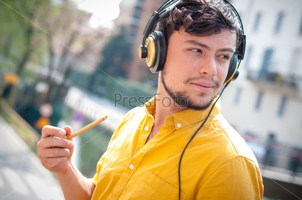 hipster young man listening to music on the balcony