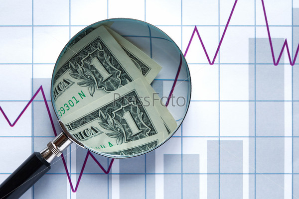 One dollar bank notes inside magnifying glass on paper background with business chart