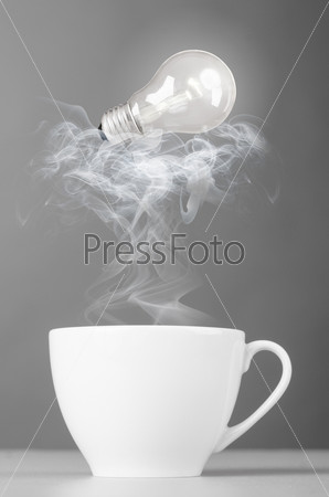 idea bulb is lying on steaming hot coffee cup
