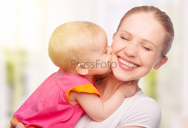 Happy cheerful family. Mother and baby kissing