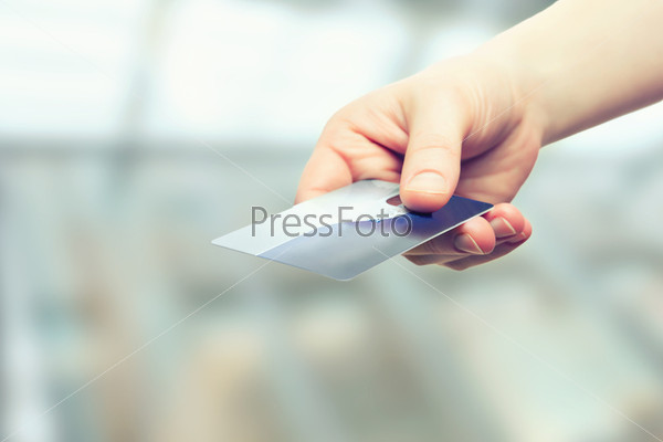 A hand with bank credit plastic card