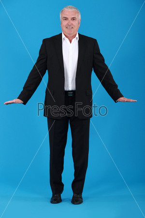 A mature businessman in a weird posture.