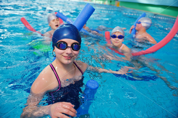 happy children kids group  at swimming pool class  learning to swim