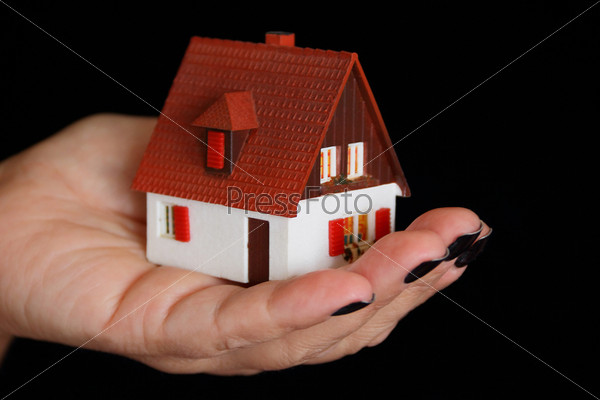 Кукольный домик в человеческой руке