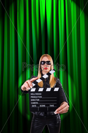 Girl with movie board against curtains, stock photo