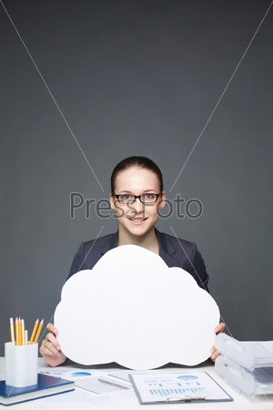 Portrait of young smiling female holding paper speech bubble and looking at camera